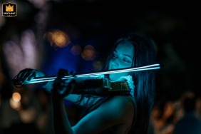 Classical violinist playing at night with illuminated fiddlestick, Magnolia Relais, Longiano, Italy.